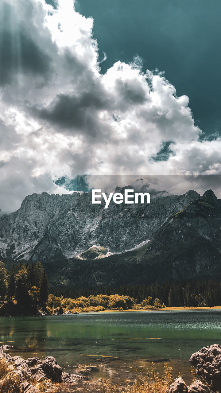 Scenic view of lake by mountains against sky