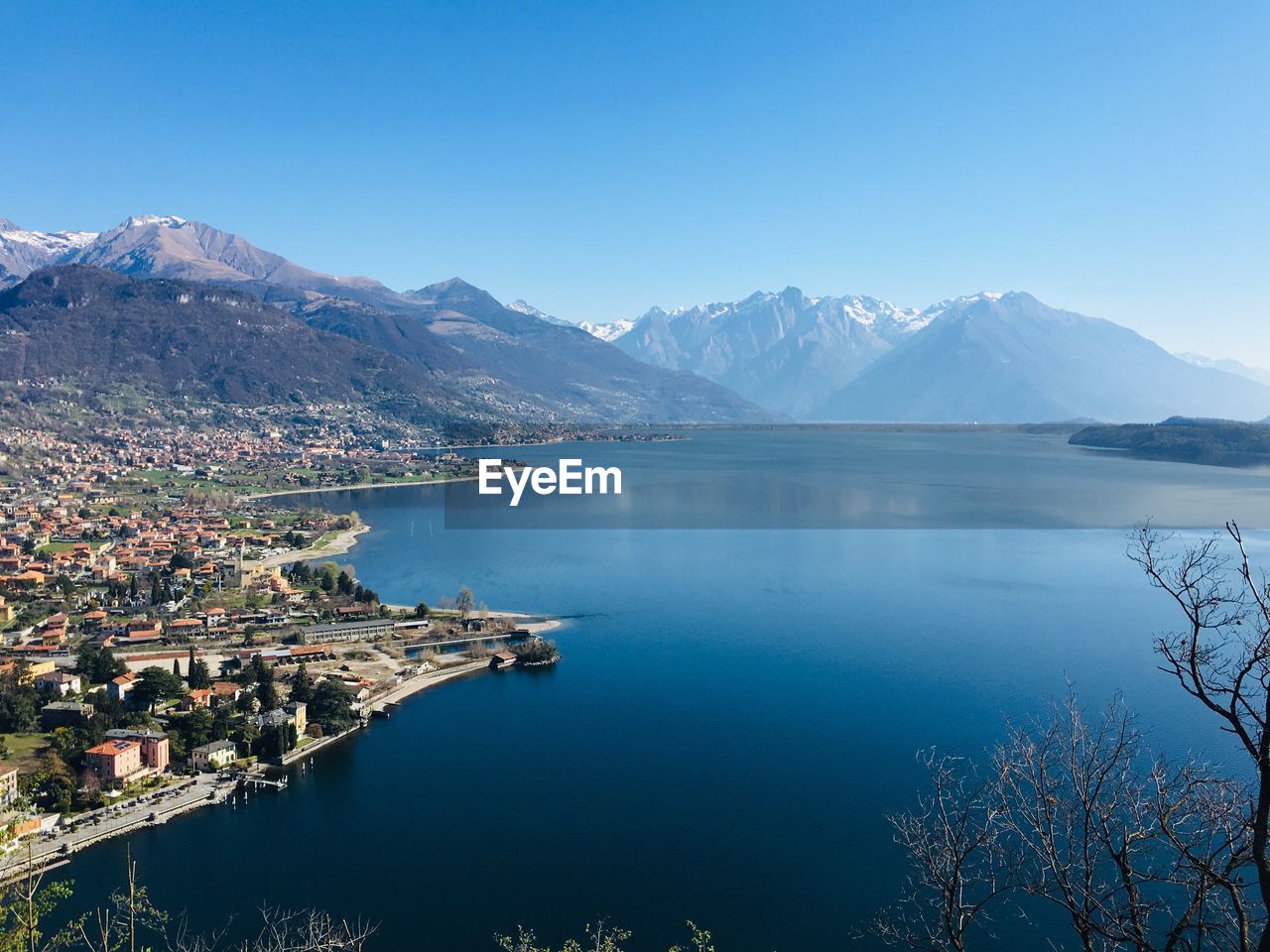 Scenic view of lake and mountains against clear blue sky