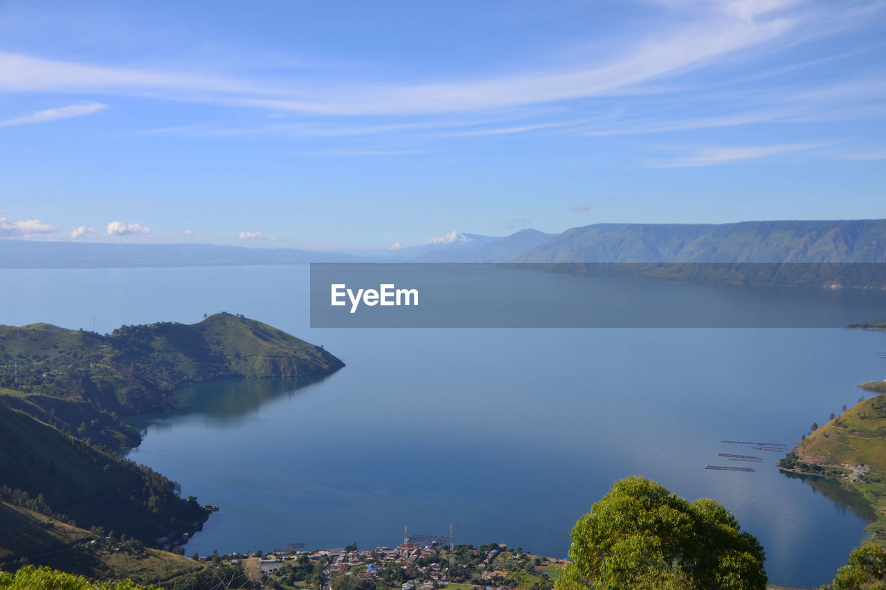 Scenic view of sea and mountains against sky