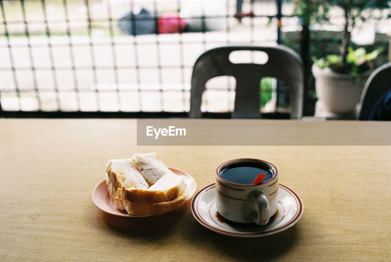 High angle view of black tea and snacks on table