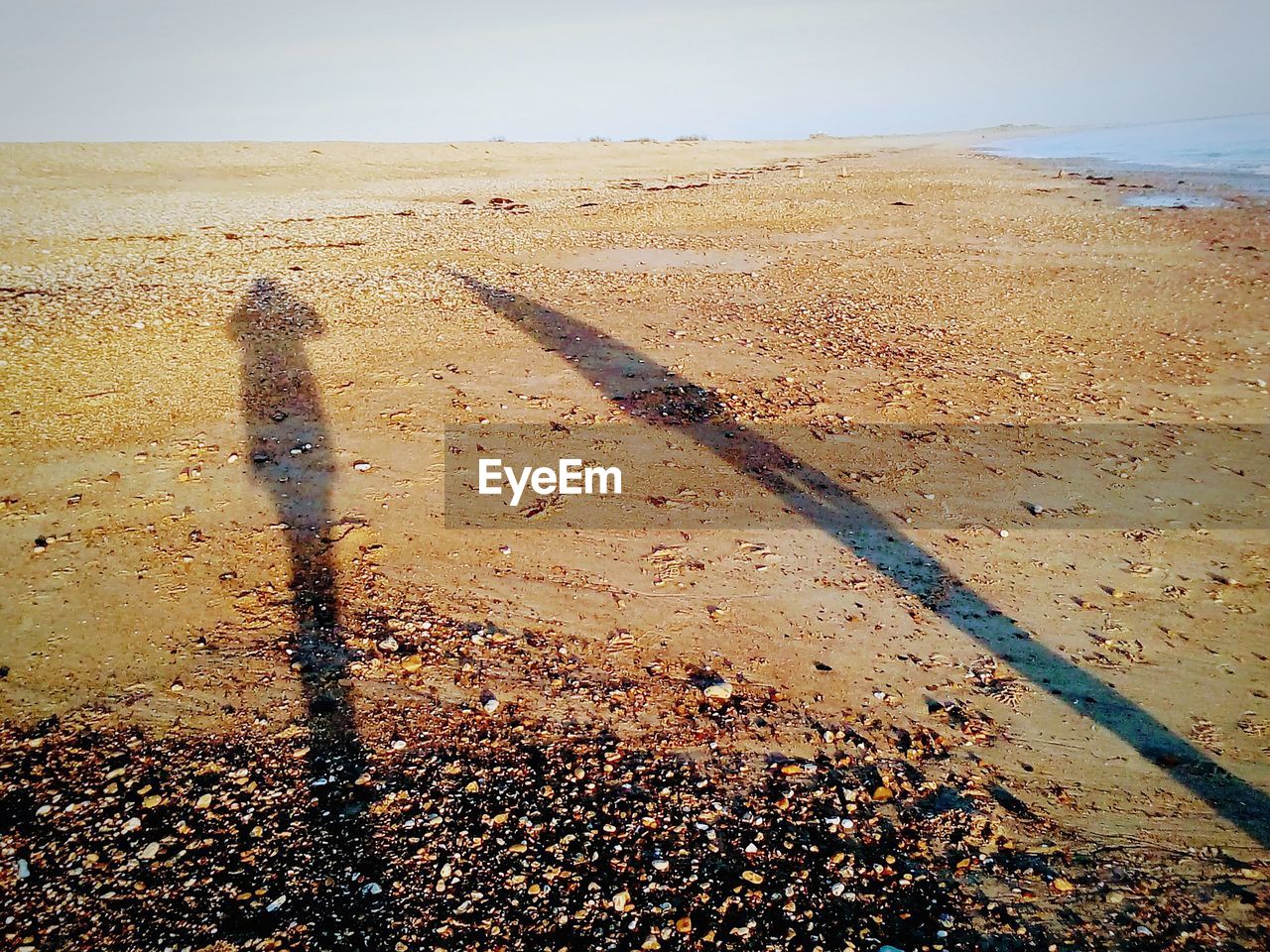 HIGH ANGLE VIEW OF SHADOW ON BEACH