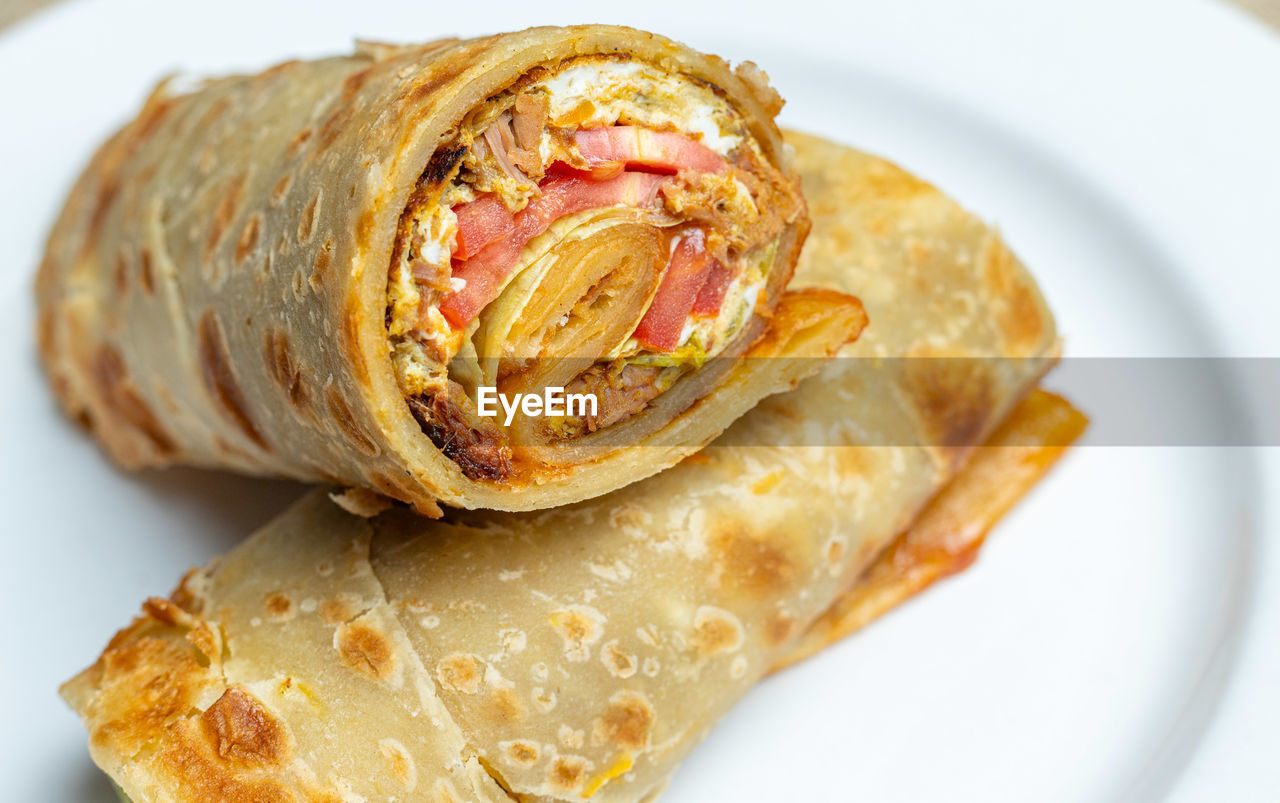 food and drink, food, sandwich wrap, burrito, dish, fast food, plate, cuisine, freshness, breakfast, healthy eating, taquito, egg roll, indoors, close-up, no people, vegetable, meal, wellbeing, produce, meat, studio shot, spring roll, fruit, bread, tortilla