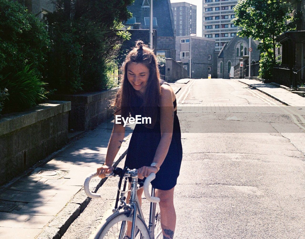 WOMAN RIDING BICYCLE ON STREET