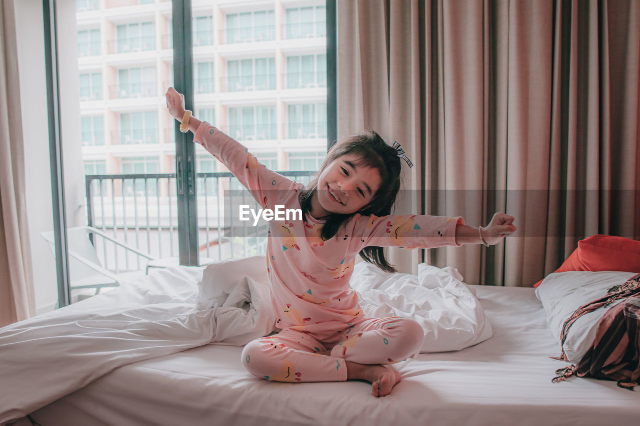 Little girl wakes up in morning in bed