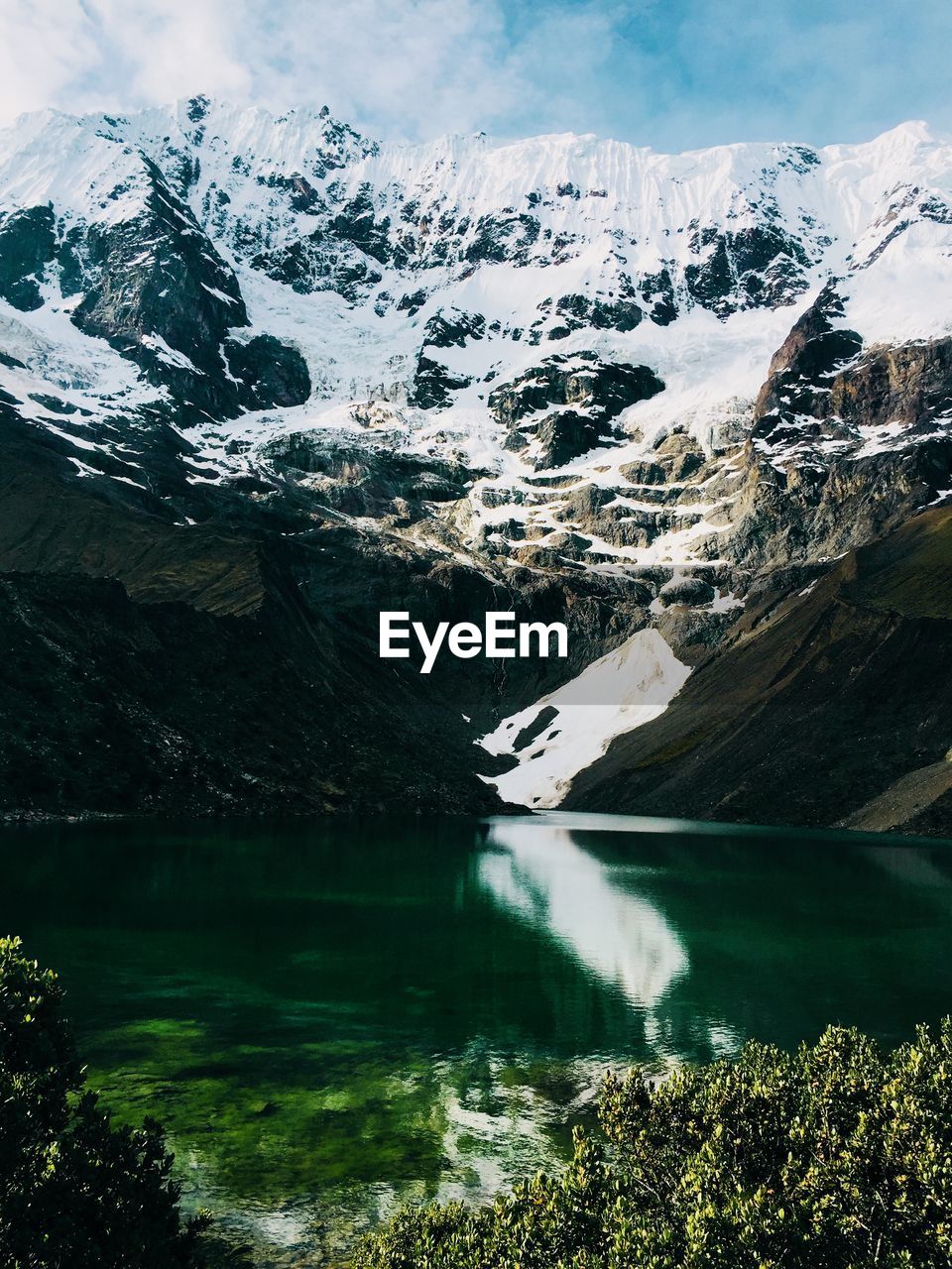 SCENIC VIEW OF SNOWCAPPED MOUNTAINS BY LAKE