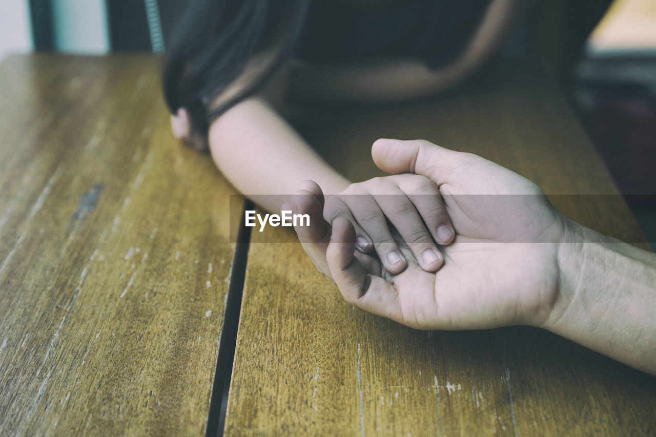 Close-up of hands on floor at home