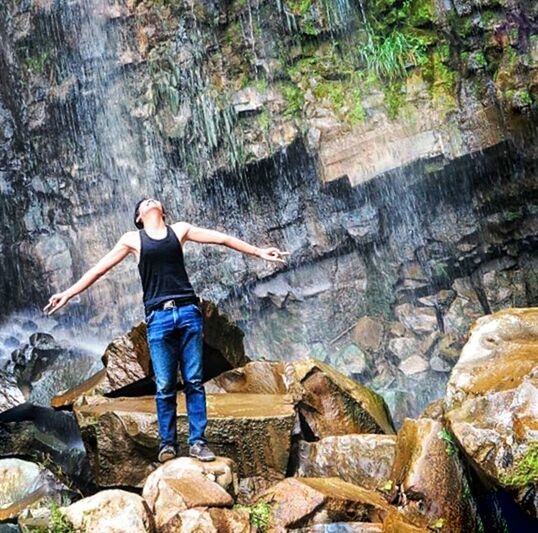 YOUNG WOMAN STANDING ON ROCK