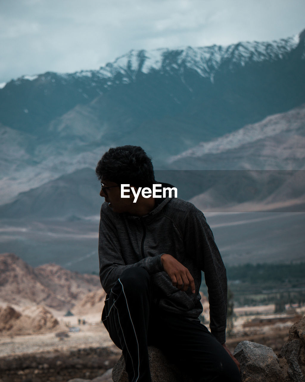 MAN SITTING ON ROCK