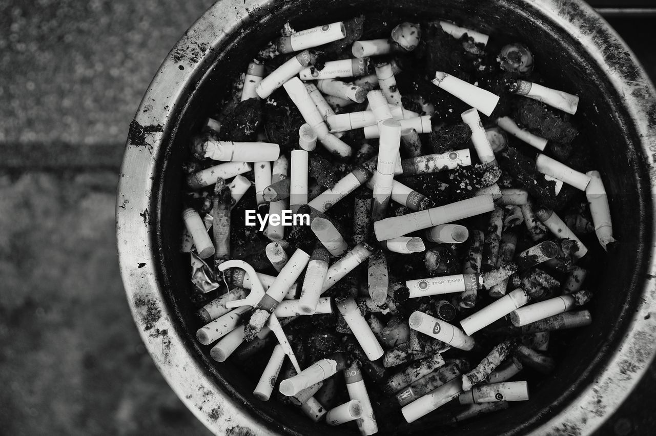 Directly above shot of cigarette butts in container