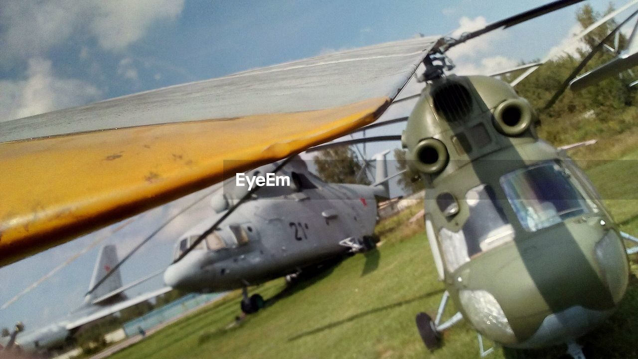 CLOSE-UP OF AIRPLANE FLYING OVER FIELD