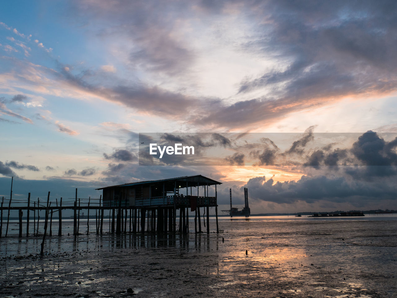 SILHOUETTE BUILT STRUCTURE ON BEACH AGAINST SKY