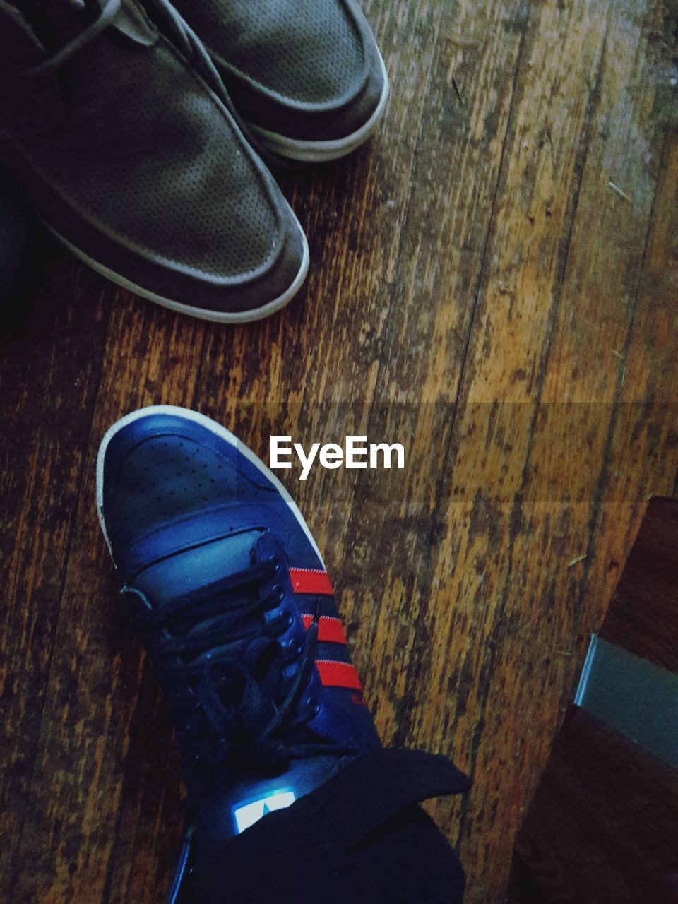 CLOSE-UP OF SHOES ON WOOD