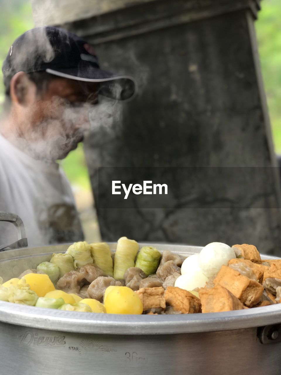 CLOSE-UP OF MAN WORKING WITH VEGETABLES