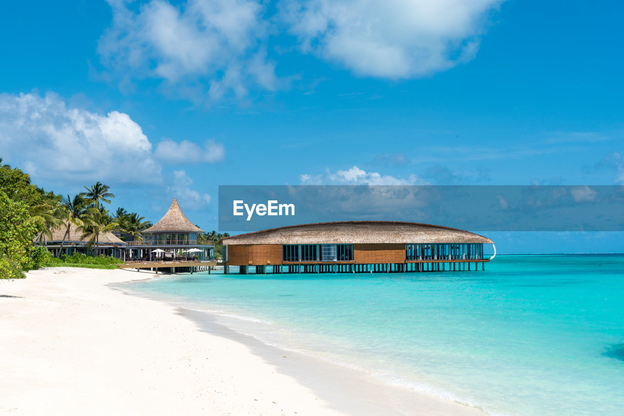 Built structures on beach against blue sky