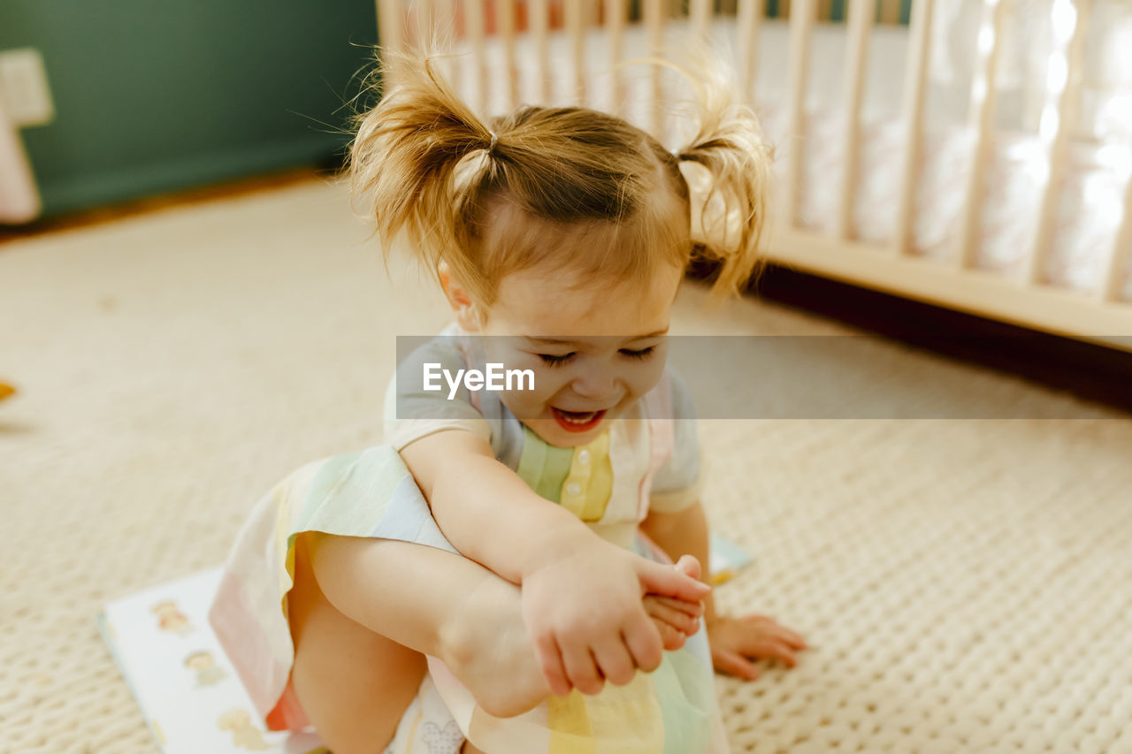 Toddler girl playing with her feet