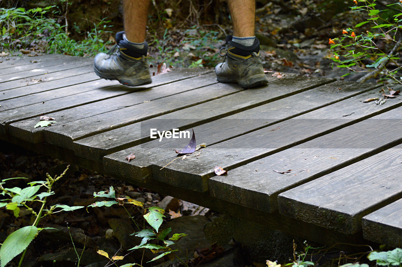 Low section of man walking on bridge