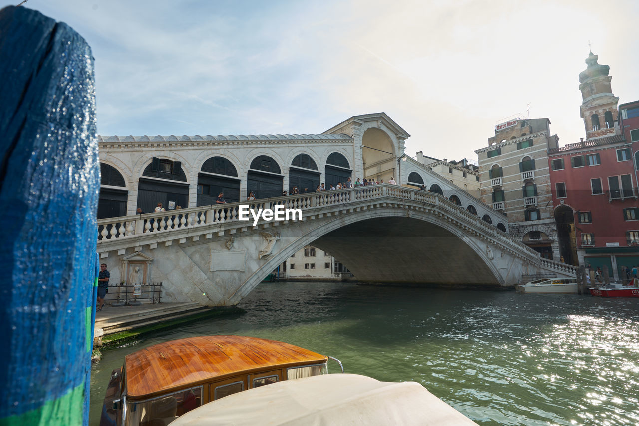 Rialto bridge over river against cloudy sky