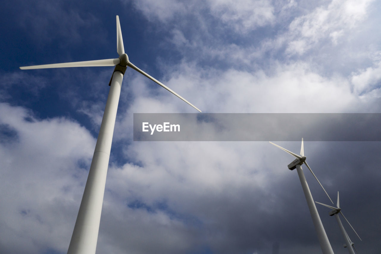 Low angle view of windmill against cloudy sky