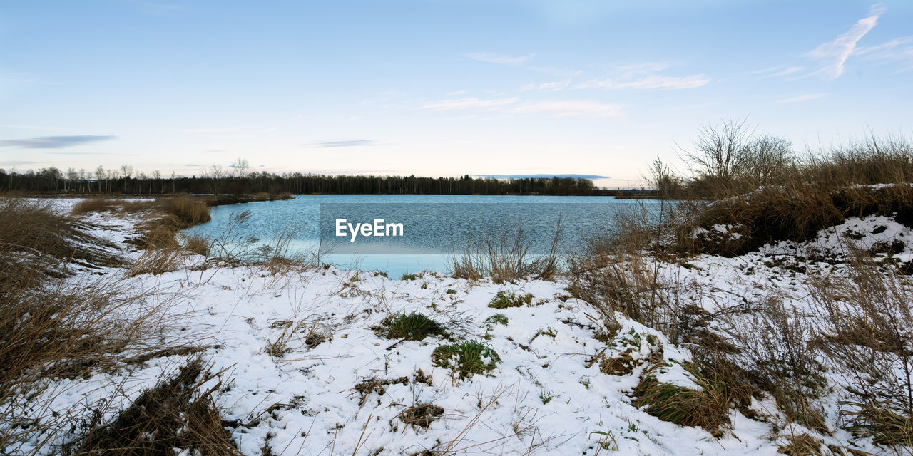 Scenic view of lake against sky during winter