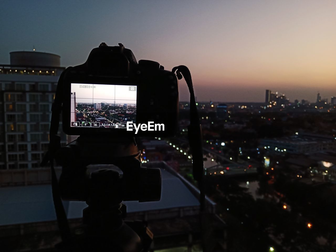 WOMAN PHOTOGRAPHING CITYSCAPE WITH CAMERA