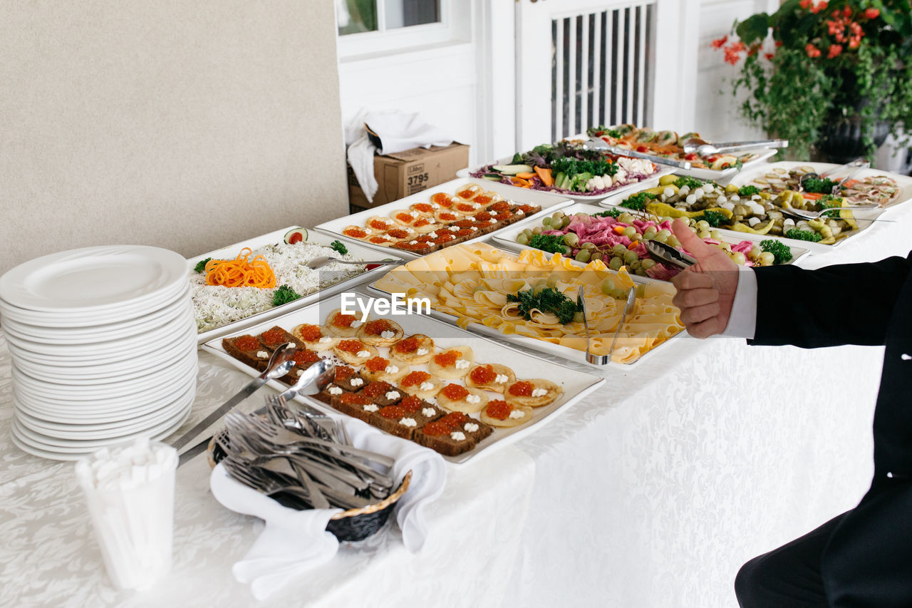 Cropped man gesturing thumbs up sign by food on table