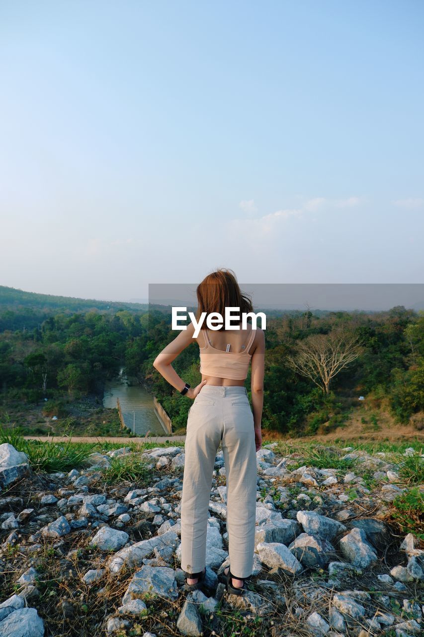 Rear view of woman standing on land against landscape