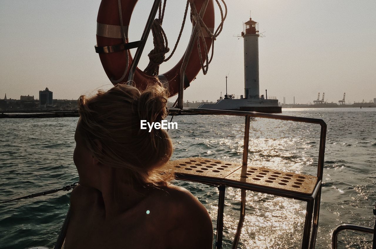 Woman in boat on sea against sky