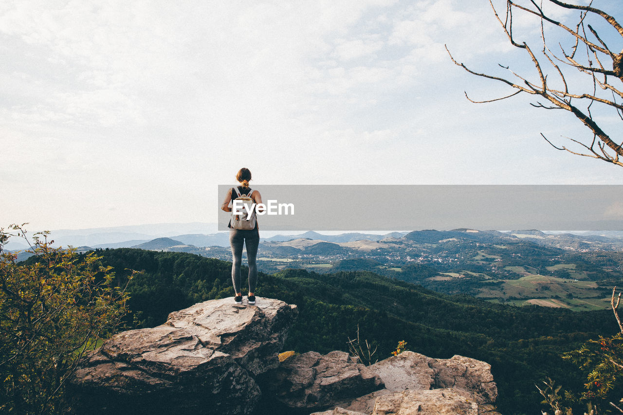 Rear view of woman standing on cliff