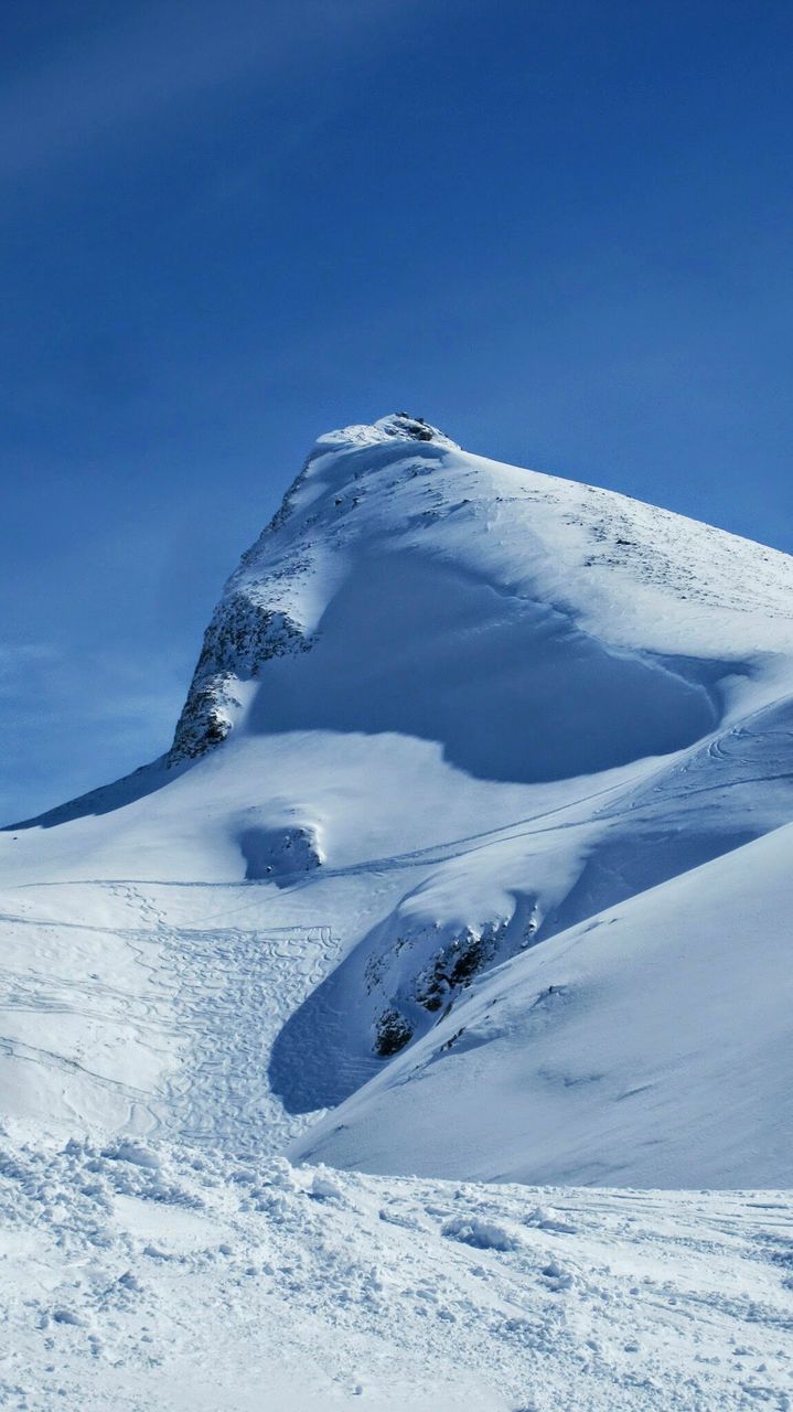 Scenic view of snowcapped mountain against blue sky