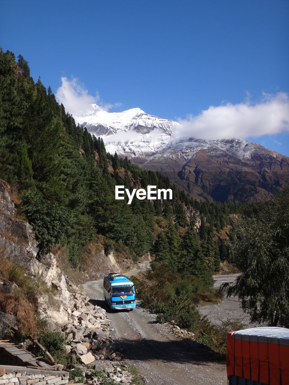 Car on road by mountains against blue sky