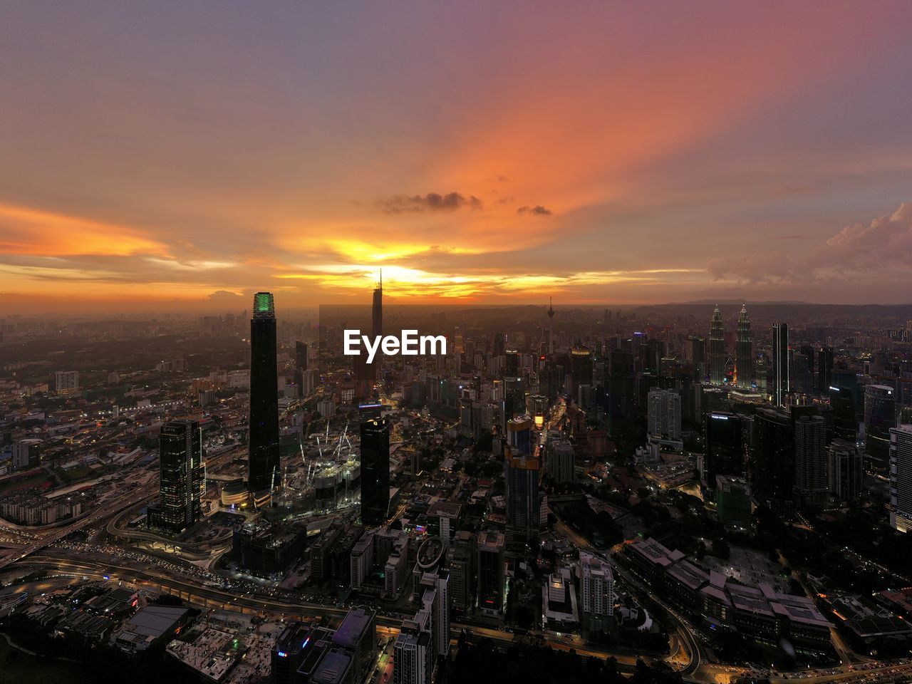 High angle view of illuminated cityscape against sky during sunset