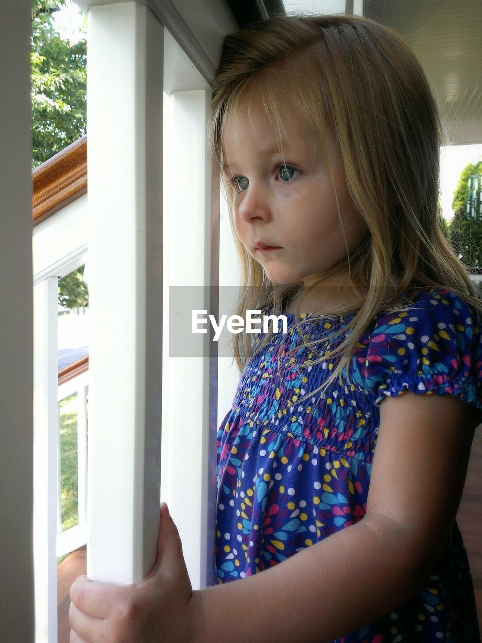 Close-up of a cute girl looking through window