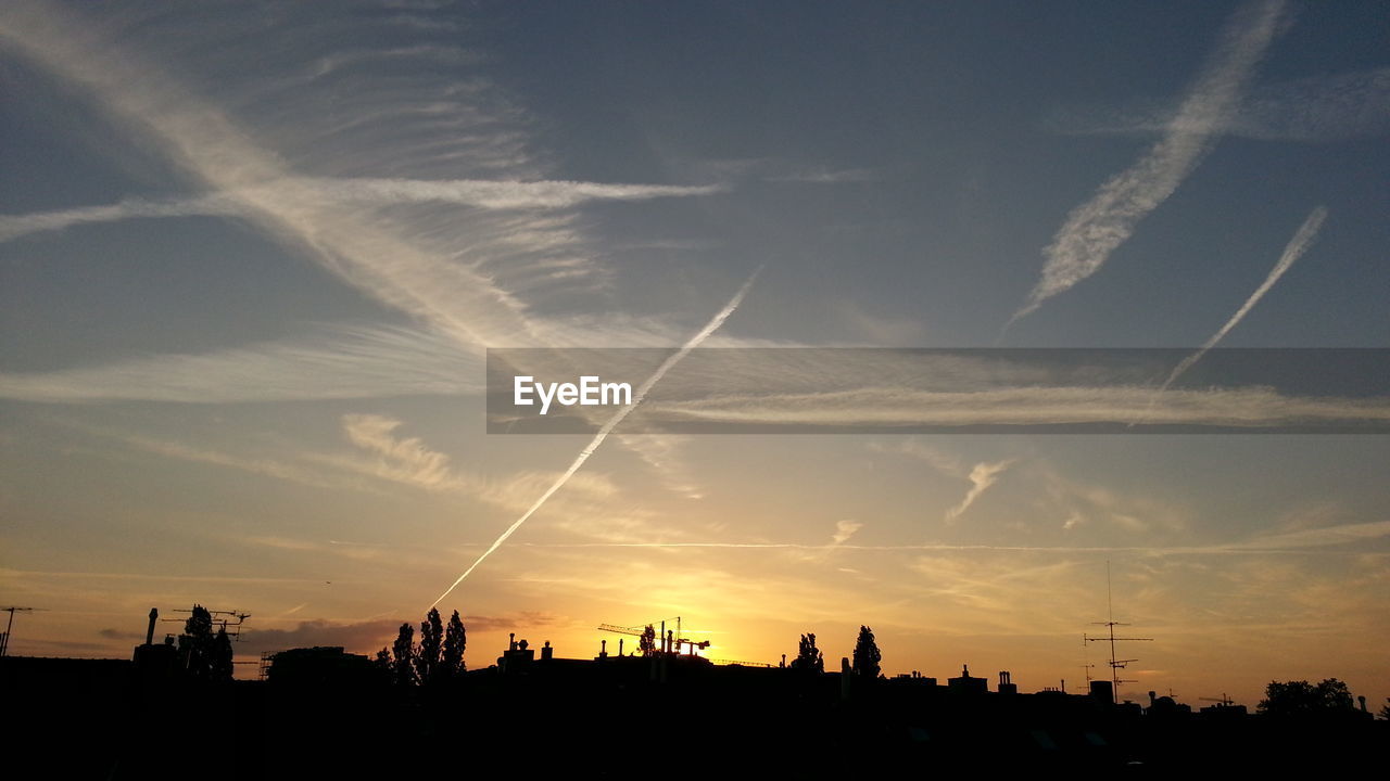 Silhouette of vapor trails in sky