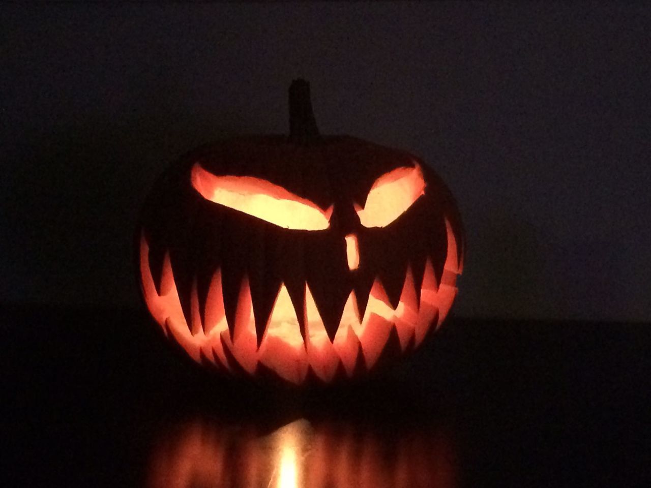 CLOSE-UP OF ILLUMINATED PUMPKIN AT NIGHT