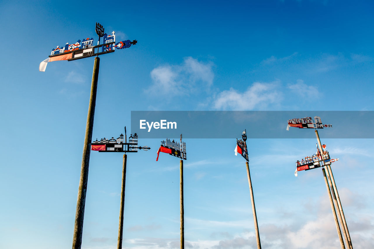 Low angle view of poles with decoration against sky