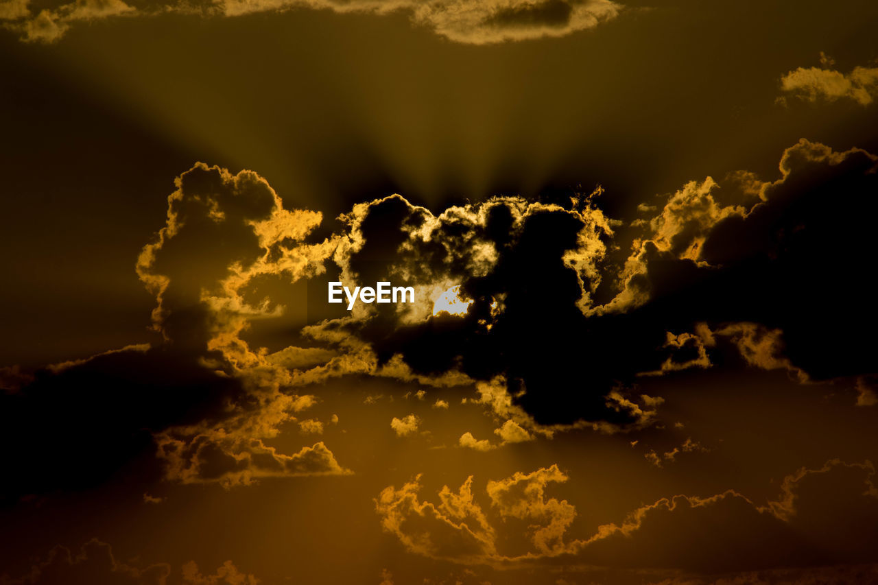 LOW ANGLE VIEW OF STORM CLOUDS AT SUNSET