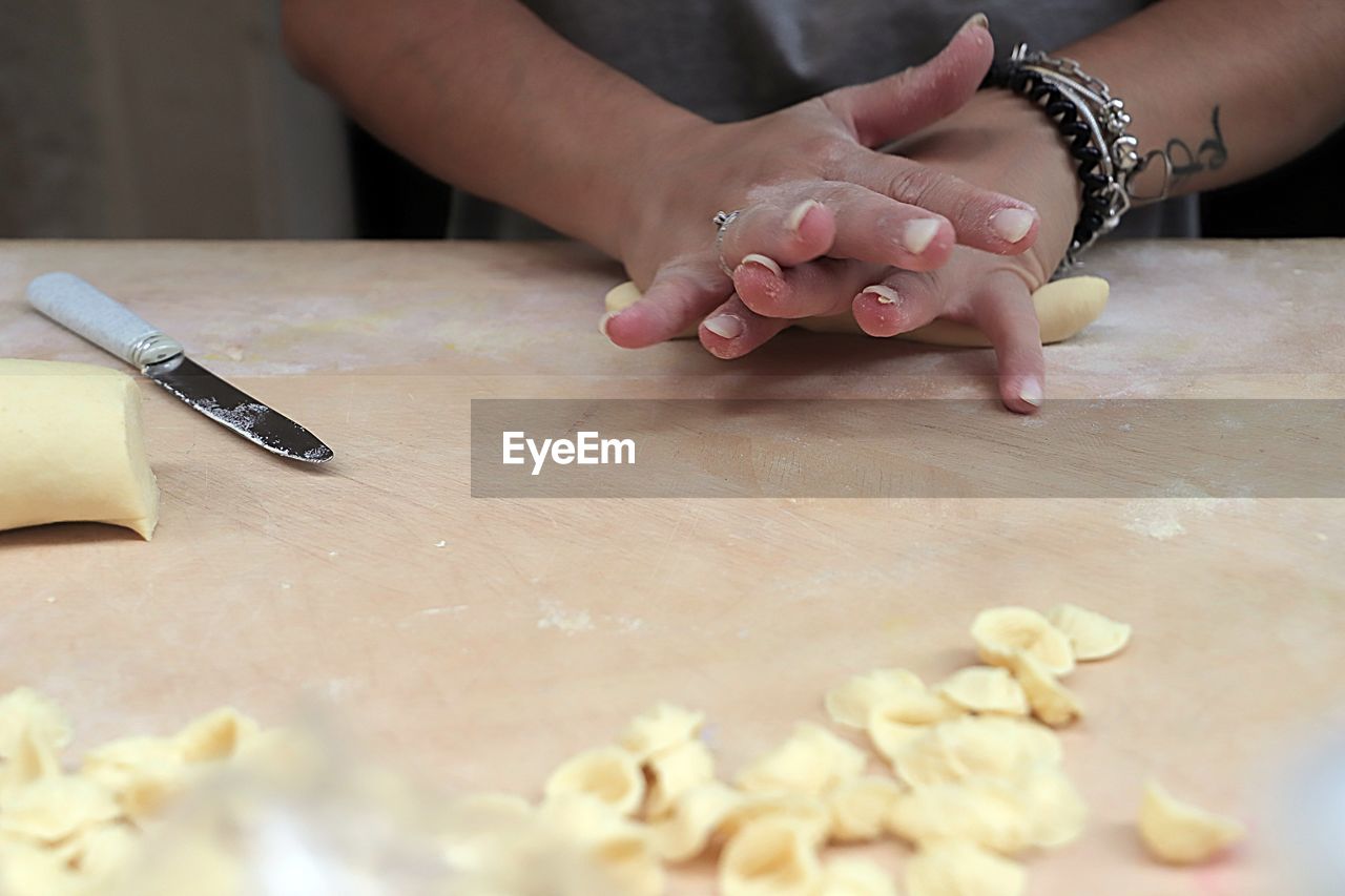 hand, baked, food, dough, indoors, food and drink, one person, women, adult, icing, kitchen, preparing food, domestic room, table, making, domestic kitchen, freshness, home, female, close-up, selective focus, lifestyles, raw food, person, domestic life, flour, child, kitchen knife, occupation