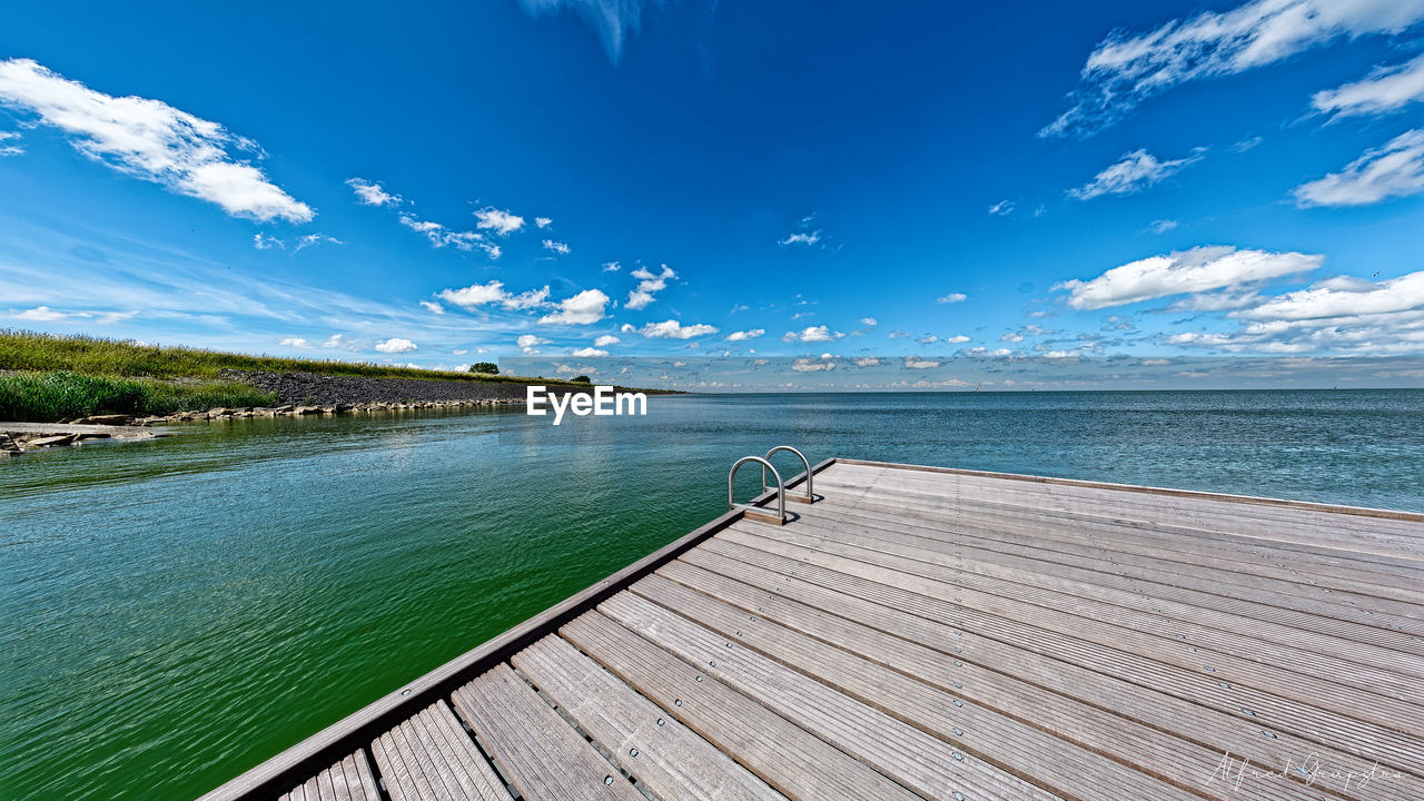 Pier over sea against blue sky