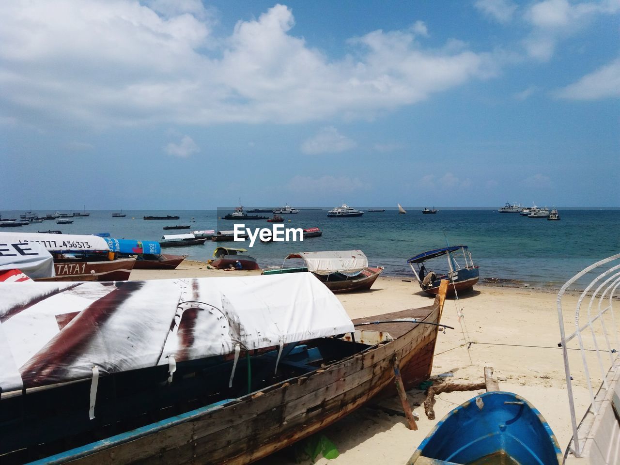 Boats moored on beach against sky