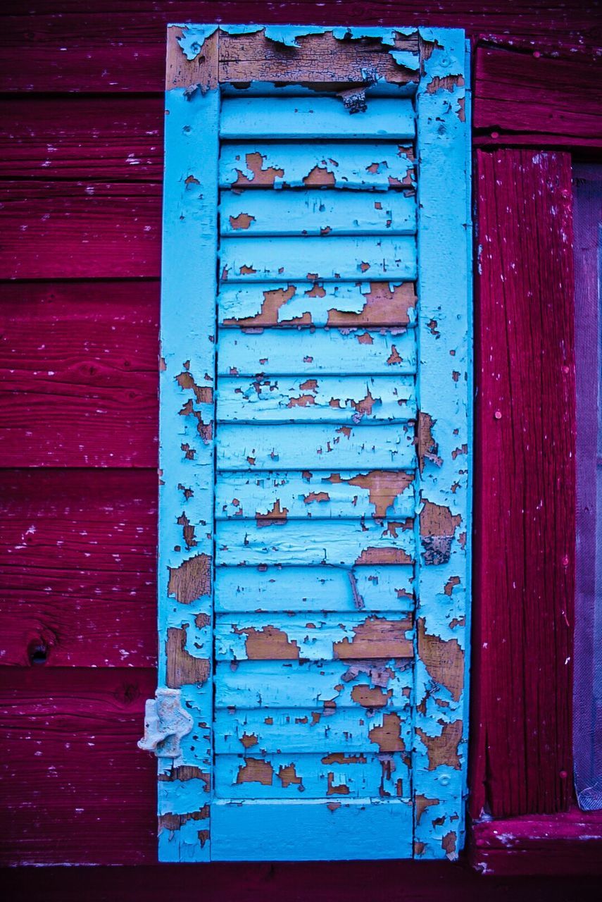 Peeled blue window of house