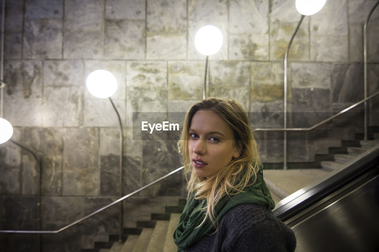 Portrait of beautiful young woman against steps