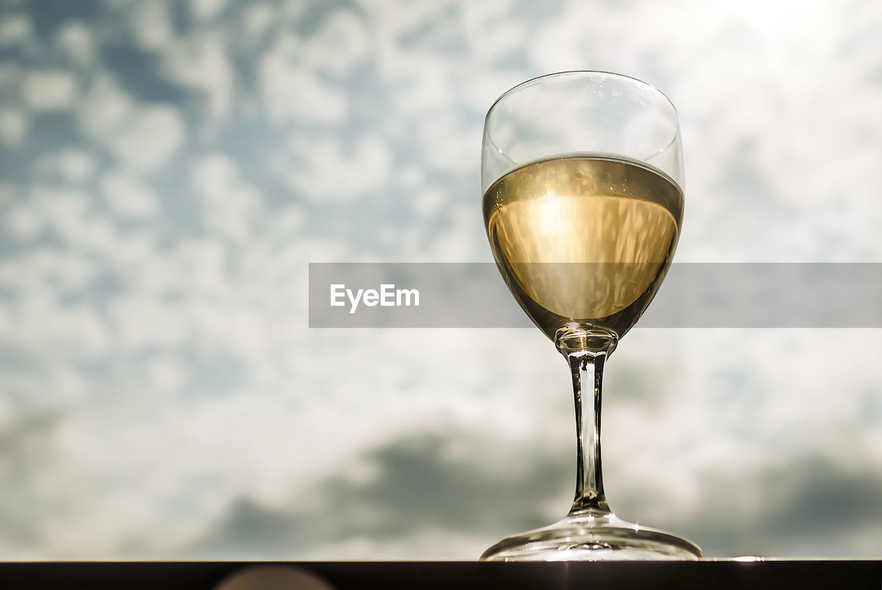 Low angle view of wineglass against sky