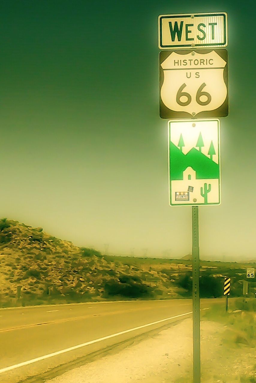 CLOSE-UP OF ROAD SIGN AGAINST SEA