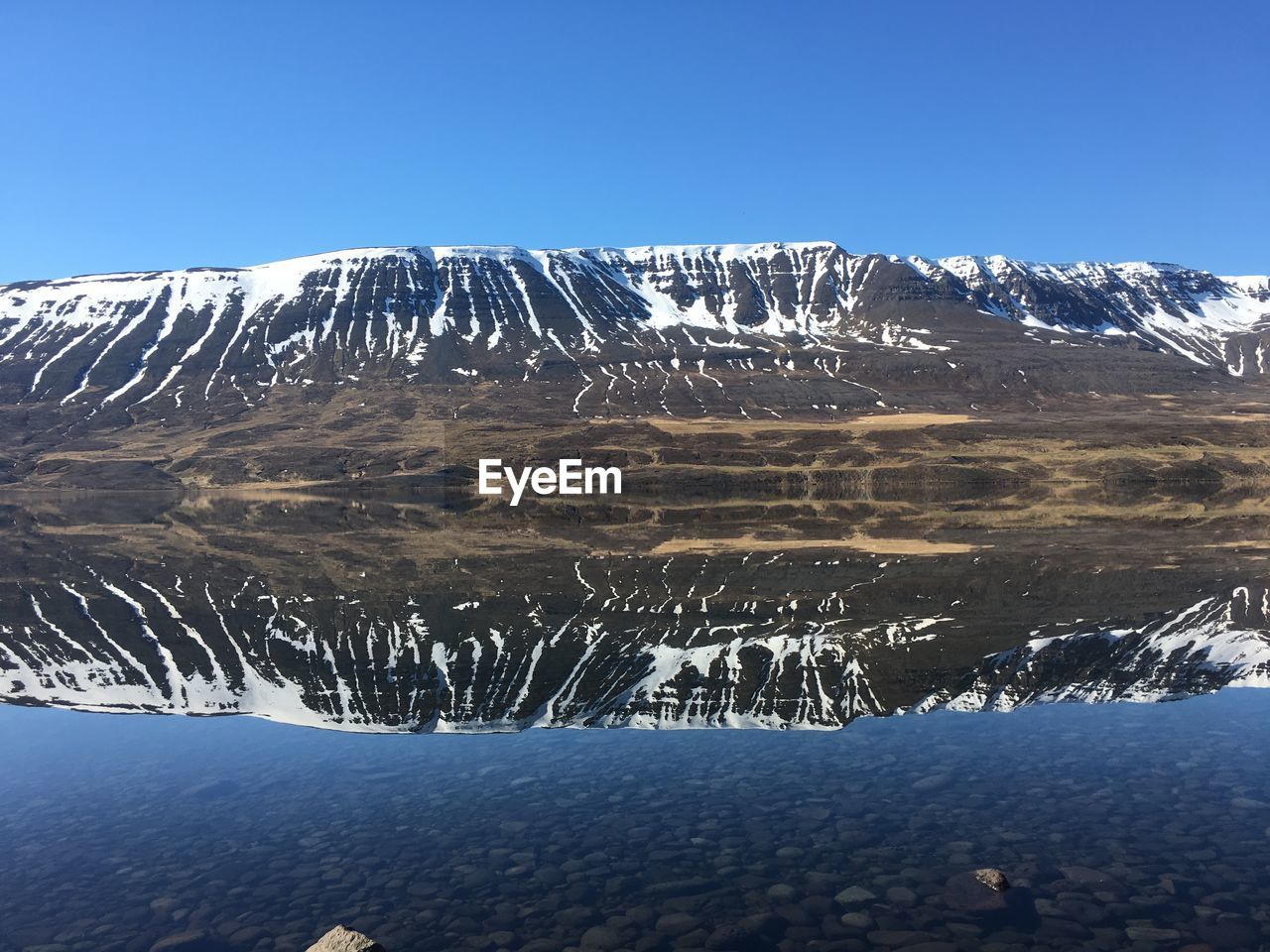 Scenic view of snowcapped mountains against blue sky