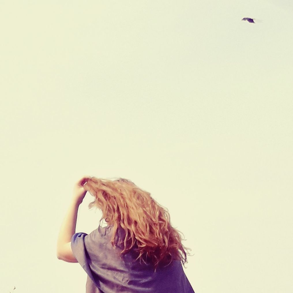 REAR VIEW OF A WOMAN AGAINST THE SKY