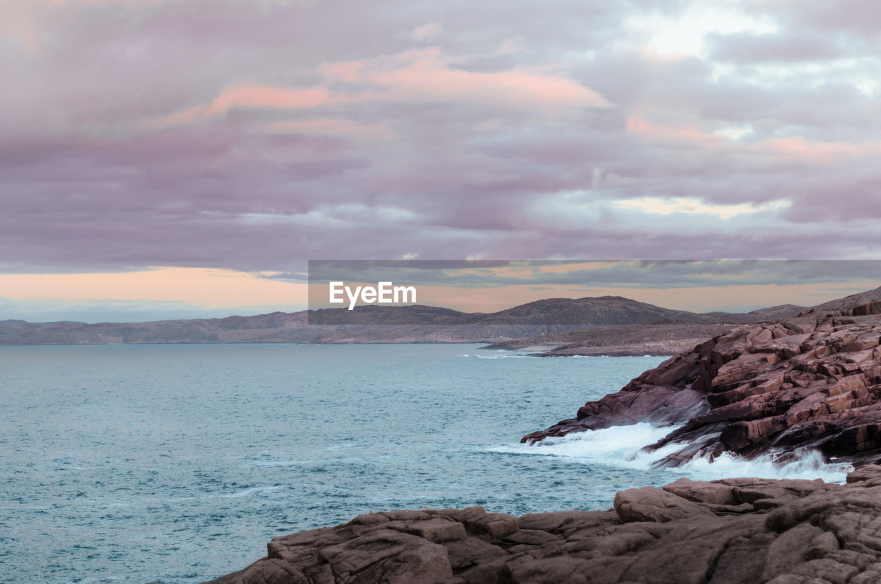 Scenic view of sea and mountains against sky