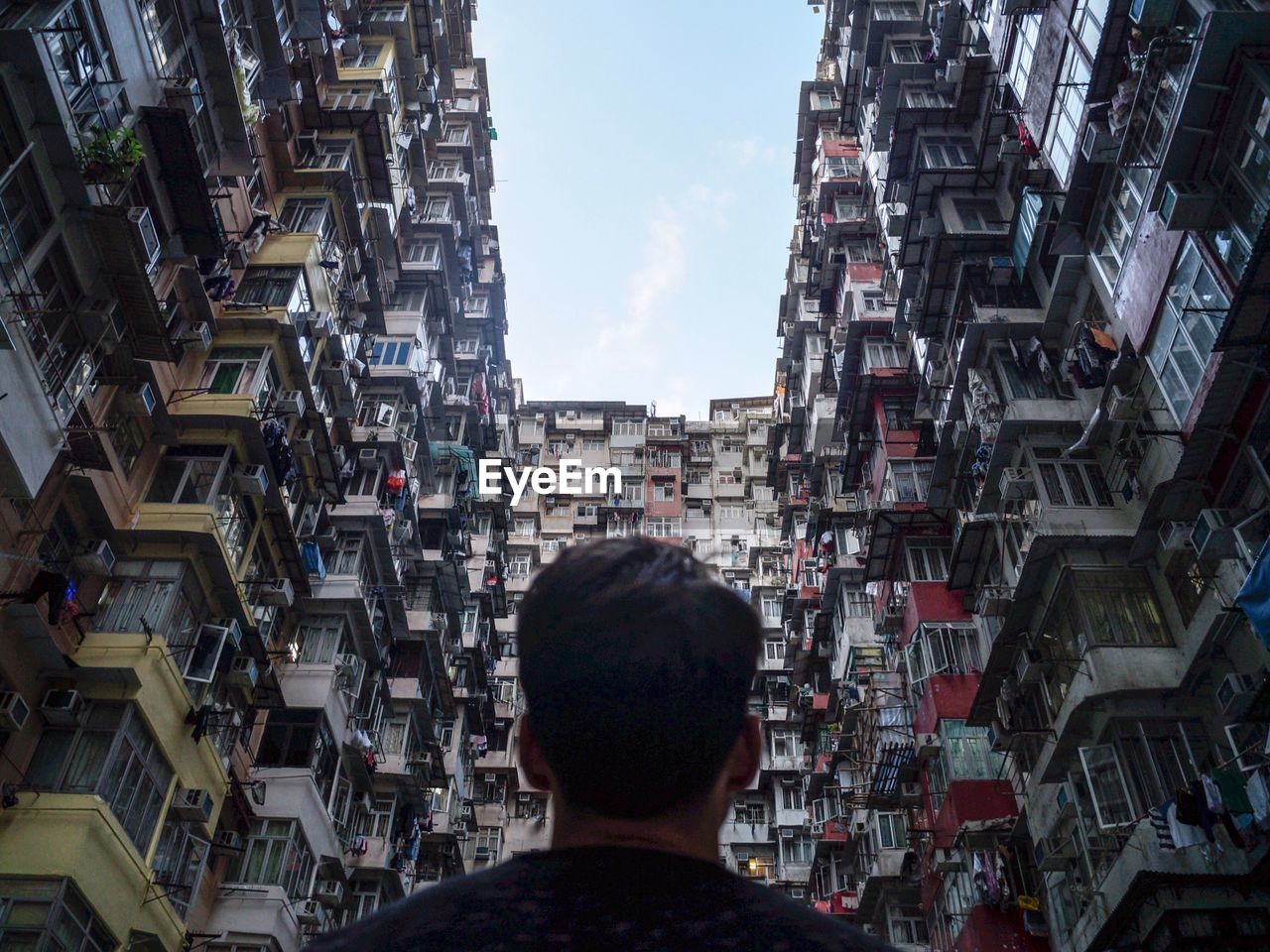 Low angle view of man standing amidst residential buildings