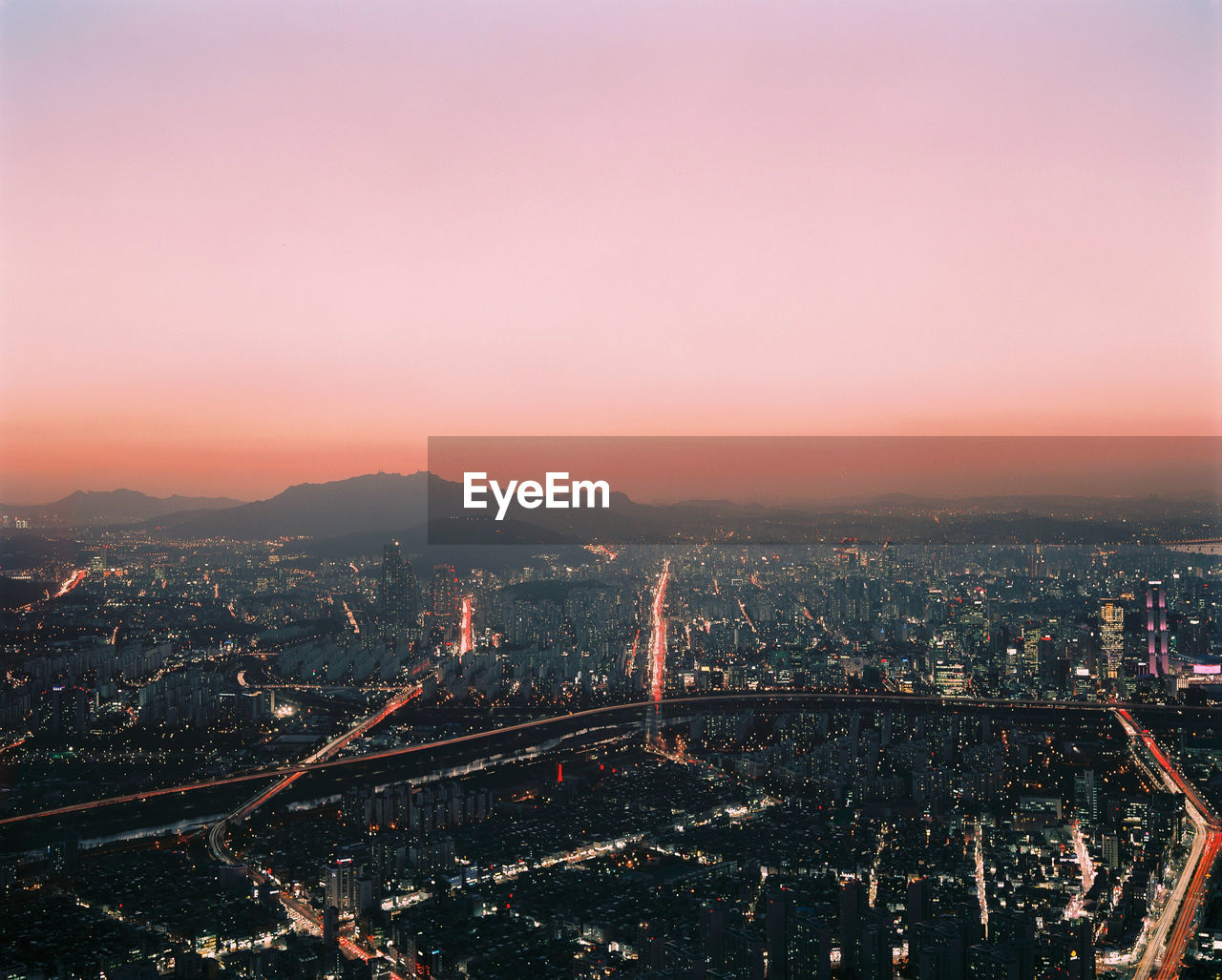 Aerial view of city lit up at sunset