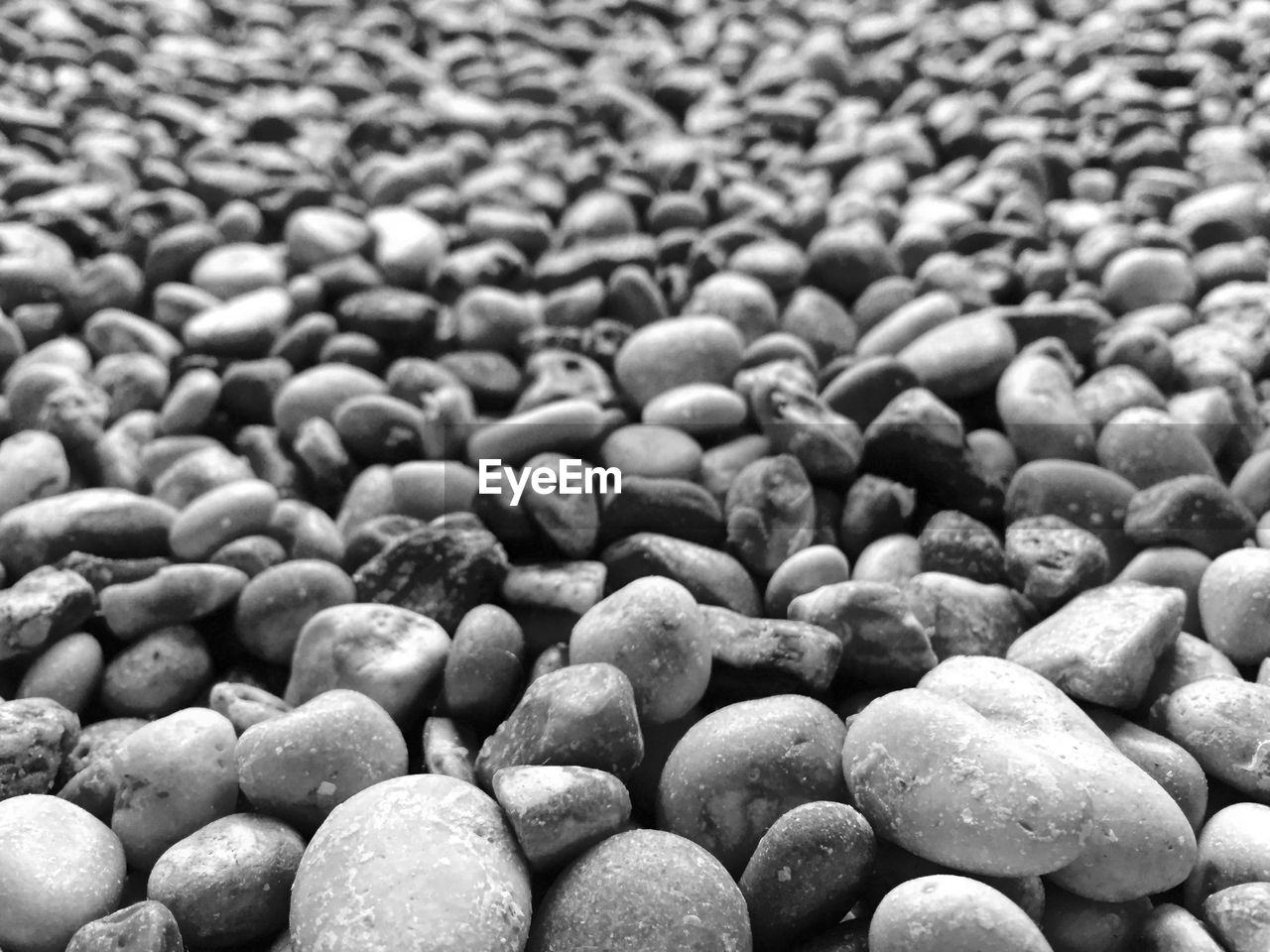 FULL FRAME SHOT OF PEBBLES ON STONES