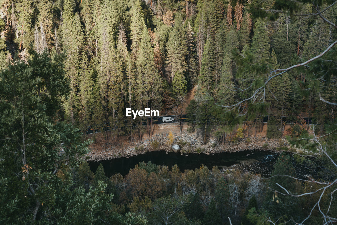 Camper van drives along the river bend